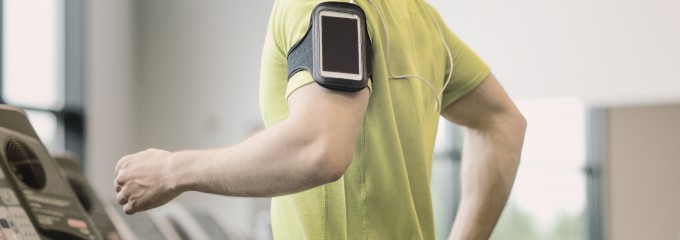 man with smartphone exercising on treadmill in gym