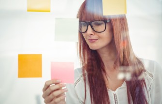 Attractive hipster woman looking at sticky notes
