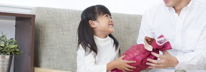 child passing gift to dad