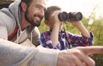 father and son looking through binoculars