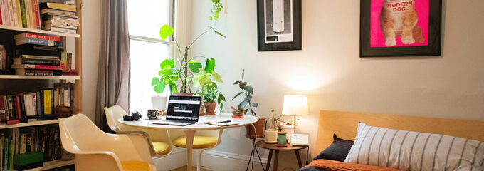 A home office set up in a warmly decorated bedroom