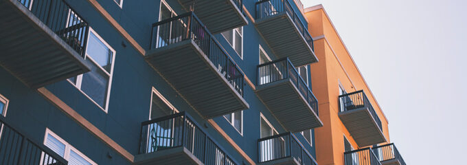 Street view of a blue and orange apartment complex