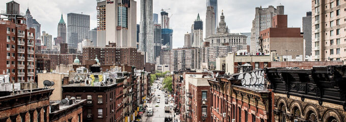 A picture of a busy street in New York City, with old brick buildings and sleek skyscrapers